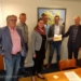Foto: Irene Bos (secretaris) in het bijzijn van Rick van Bostelen, Geert Bijleveld, Rudi Rondhuis en Ap Ploegh de ondertekende akte in ontvangst