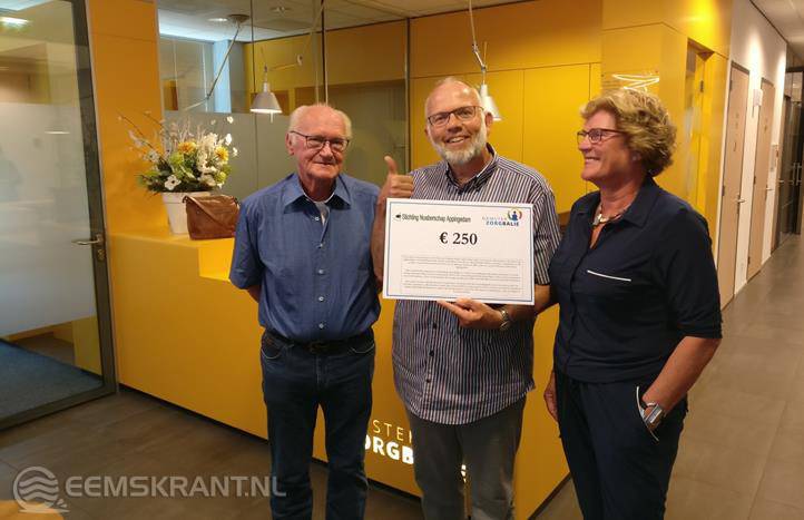 Wiebe Zijlstra (gastheer) en Albertha Jagersma (gastvrouw) overhandigen de cheque aan Arie Schuur (midden) van de Stichting Noaberschap Appingedam.