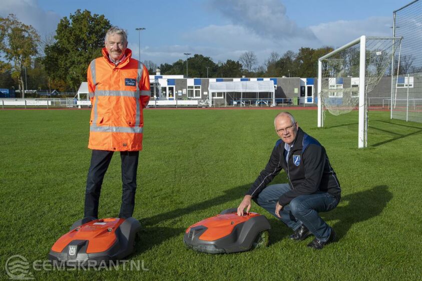 Wethouder Jan Menninga (links) en de voorzitter van NEC Delfzijl, Emme Groot (rechts) namen de robotmaaiers in gebruik.