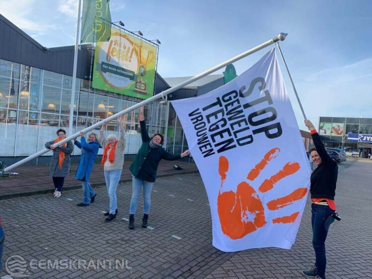 Leden van Soroptimistclub de Eemsmond hijsen de vlag op het Woonplein