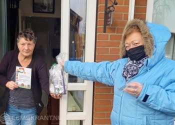 Foto: Siena Engels van de huurdersorganisatie Scheemda geeft een huurder een opstekertje. (Eigen foto).