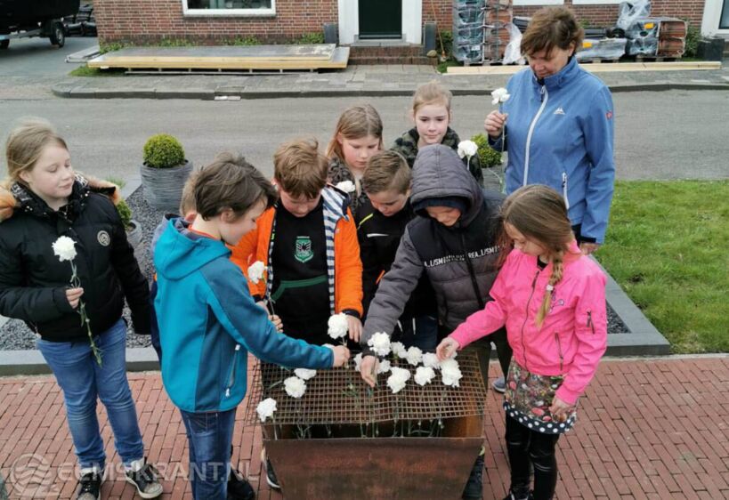 Leerlingen leggen elk een anjer neer bij het Canadese monument. Eigen foto