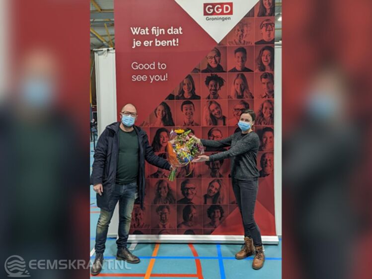 Marcel Visser (GGD) reikt Esther een bos bloemen uit