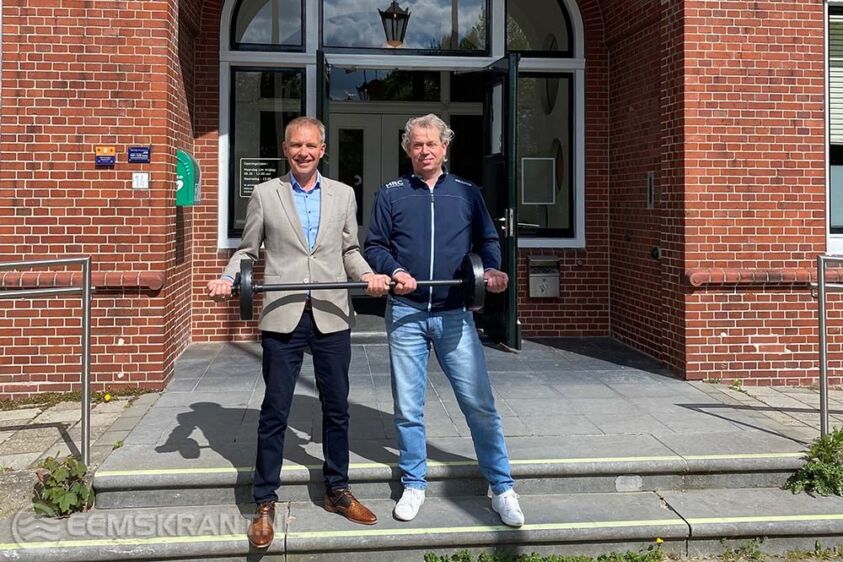 Wethouder Meindert Joostens en Jeroen Laarhuis (HRC Powerful Ageing) tillen gezamenlijk een halter om de samenwerking tussen de gemeente en HRC te bekrachtigen.