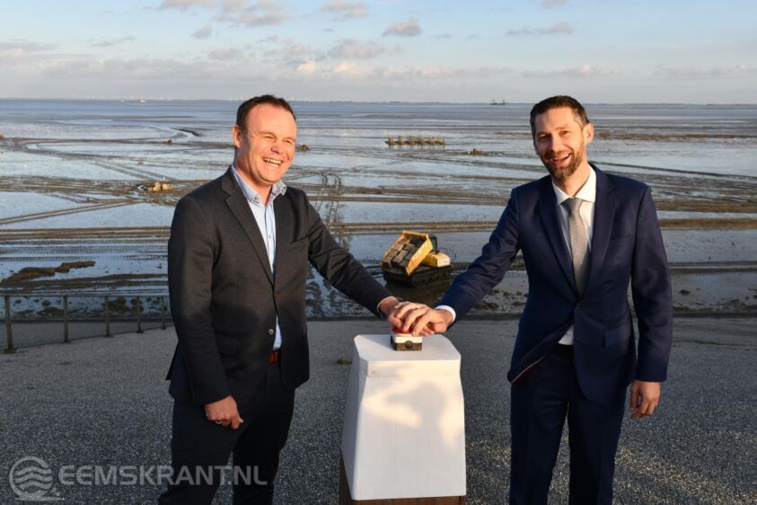 Met een druk op de knop zetten Gerben Huisman en Johan Hamster de plaatsing van rifblokken op het Wad onderaan de dijk in werking. Foto provincie Groningen