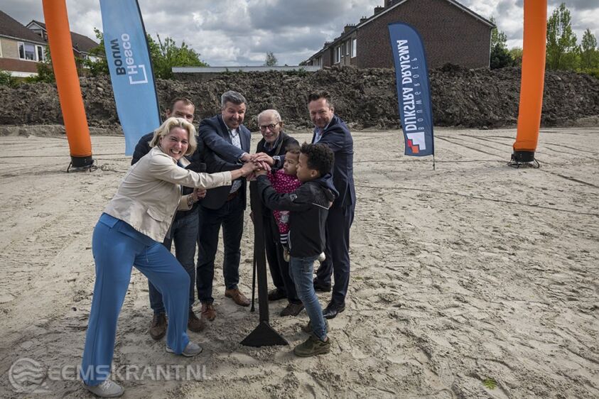 Met een druk op de knop geven Annalies Usmany-Dallinga (wethouder gemeente Eemsdelta), Jaap Groenhagen (directeur Versterking NCG Eemsdelta), Ralf Holthuis (directeur Hesco Bouw) en Gerard Jongsma (projectleider BGDD) samen met de jongste en oudste bewoner het startsein. Foto: Jan Zeeman