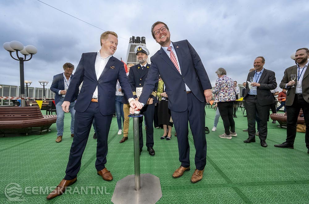 Morten Aggvin, CEO Holland Norway Lines en Tim Kruithoff, burgemeester van Emden, laten op het Sundeck met een druk op de knop de scheepshoorn blazen. Daarmee is de nieuwe thuishaven van HNL in Emden officieel geopend. In het midden kapitein Mark Rolie. Foto: Holland Norway Lines