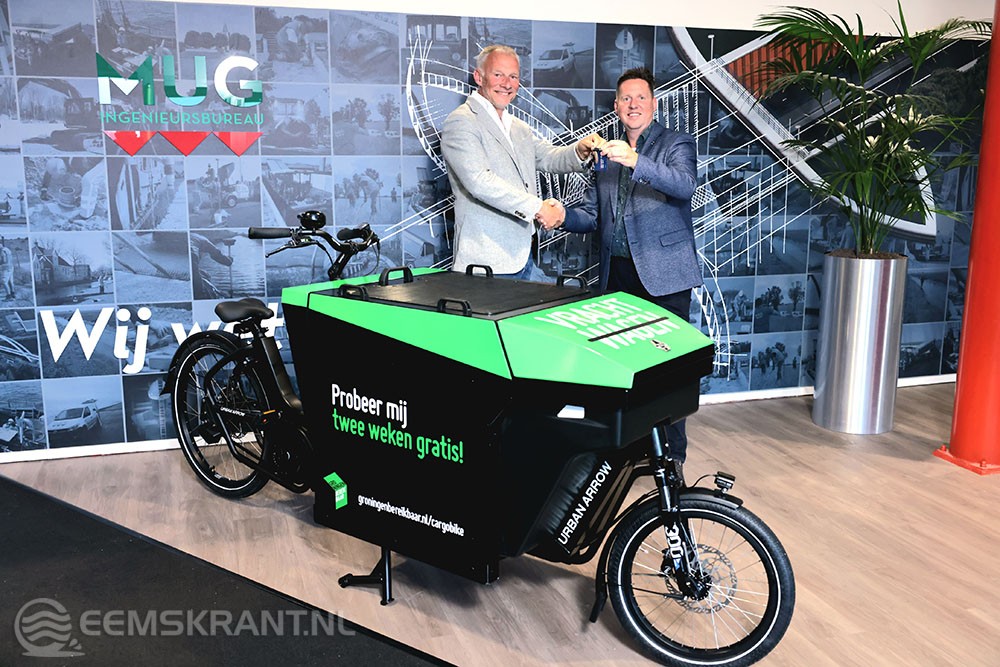 René Schripsema (Groningen Bereikbaar) reikt elektrische cargobike uit aan Edwin Oostinga (MUG Ingenieursbureau)