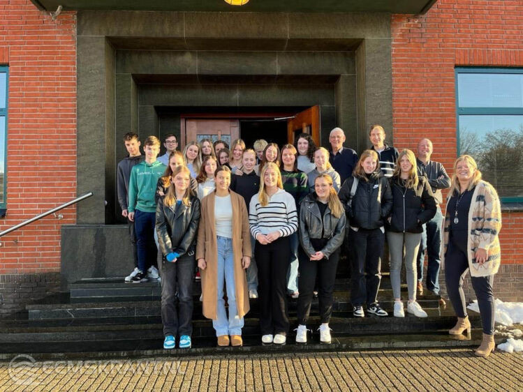 Leerlingen van de vierde klas van het Dollard college samen met een aantal raadsleden en een raadsadviseur bij het gemeentehuis in Delfzijl.