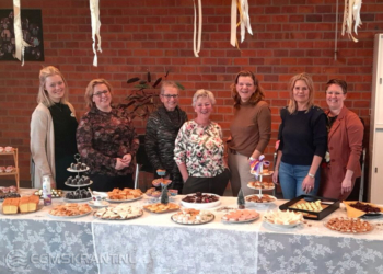 De vrijwilligers van Stichting Present Midden Groningen achter de tafel vol hapjes