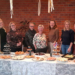 De vrijwilligers van Stichting Present Midden Groningen achter de tafel vol hapjes