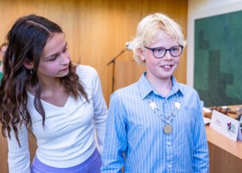 Oud-kinderburgemeester Mara Staal hangt de ambtsketen om bij haar opvolger Joep van Bergen.