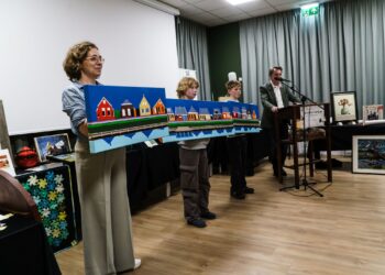 CHC-voorzitter Els Zwerver toont met assistenten Mia en Anno een drieluik van Anneke Bakker, dat afgehamerd wordt door Erik Boerma, geheel rechts. – Foto: Geert Boiten